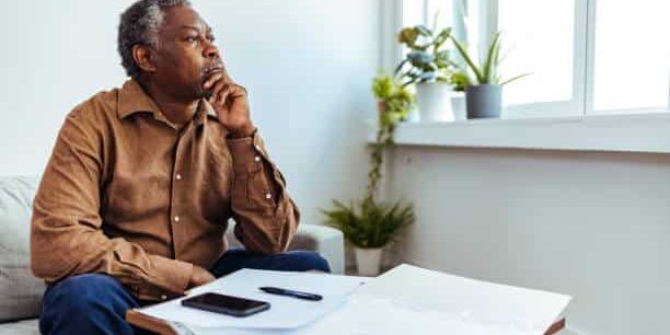 Homme de couleur noir qui réfléchit Homme de couleur noire qui réfléchit en regardant au loin